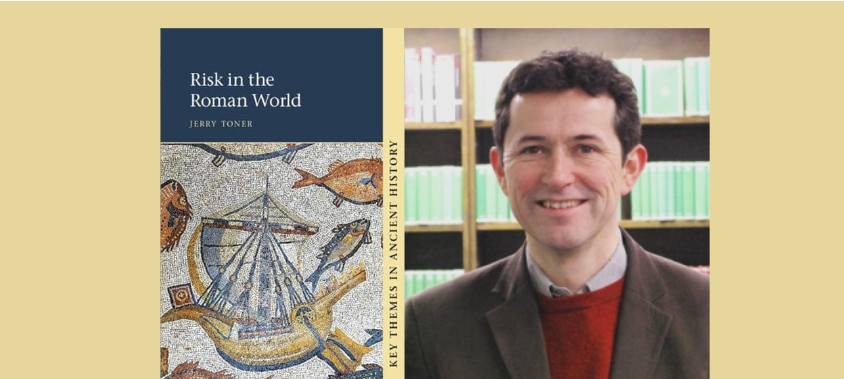 Book cover of Risk in the Roman World by Jerry Toner features a mosaic of a ship and aquatic creatures. Beside it, a man with dark hair, wearing a brown jacket and red sweater, stands smiling, against a background of bookshelves.