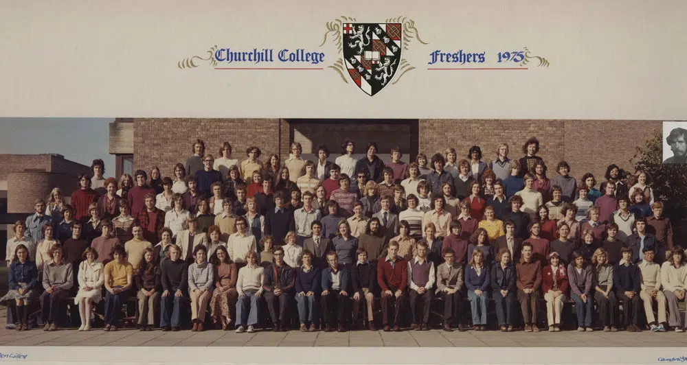 Group photo of Churchill College freshers in 1975. A large group of people is seated and standing in rows in front of a brick building. The college crest and Churchill College Freshers 1975 text are displayed at the top, with a small image inset at the top right.